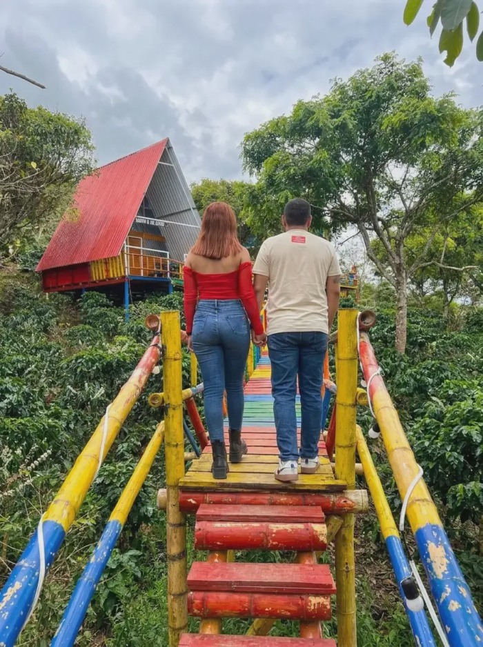 Pareja caminando hacia una cabaña para pareja entre cafetales, Finca La María