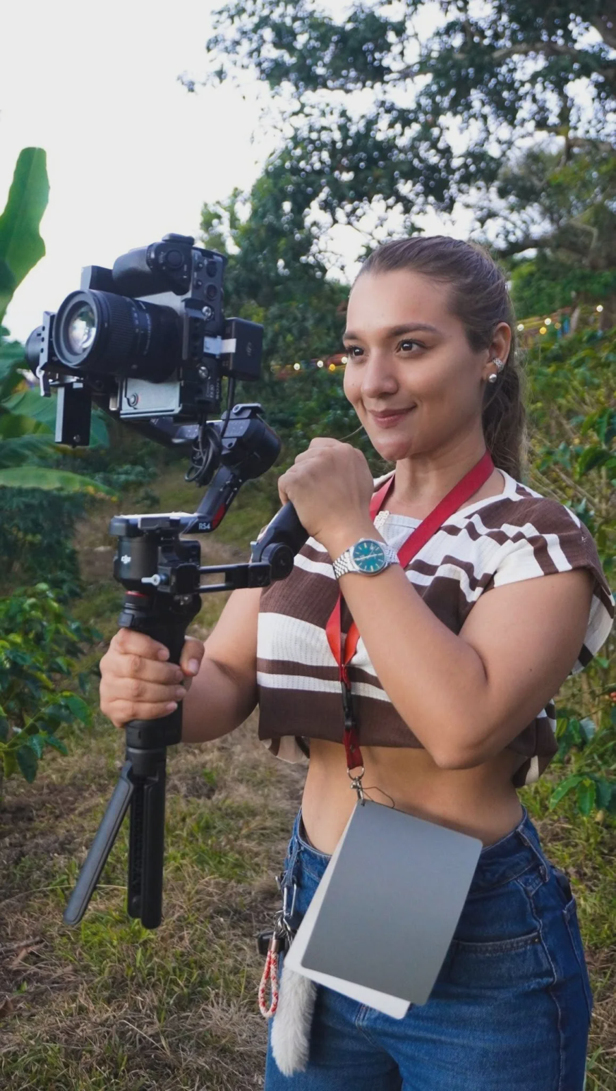 Turista y vide&oacute;grafa grabando la inmersi&oacute;n cafetera con un estabilizador de c&aacute;mara profesional entre los cafetales de la Finca La Mar&iacute;a, Huila
